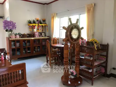 Charming living room with wooden furniture and nautical decor, featuring a cozy dining area and ample natural light.