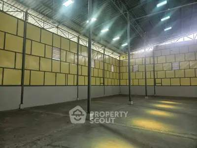 Spacious industrial warehouse with high ceilings and ample natural light.