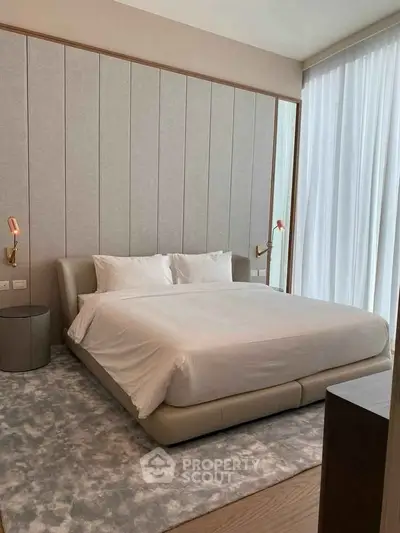 Luxurious modern bedroom with elegant decor and large windows for natural light.