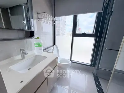 Modern bathroom with city view, featuring sleek fixtures and large window for natural light.