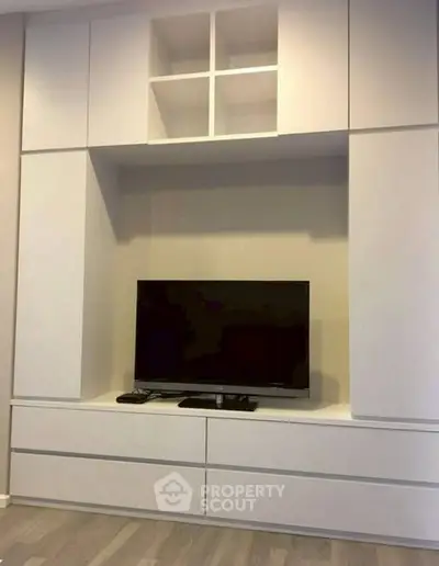 Modern living room with sleek built-in entertainment unit and flat-screen TV.