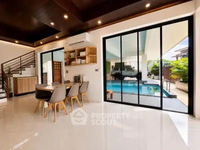Modern dining area with pool view and sleek interior design