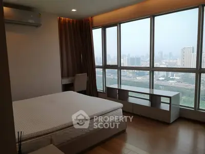 Spacious bedroom with panoramic city view and modern furnishings
