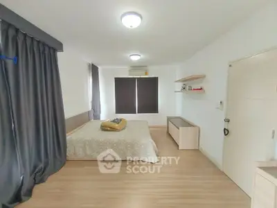 Spacious bedroom with modern decor and natural light, featuring a cozy bed and stylish furnishings.