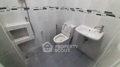 Compact bathroom with modern fixtures and tiled walls
