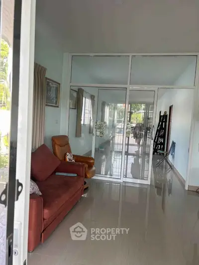 Spacious living room with glass partition and modern furnishings