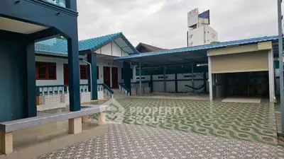 Spacious residential property with unique patterned driveway and covered parking area.