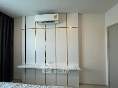 Modern bedroom with stylish wall paneling and air conditioning unit.