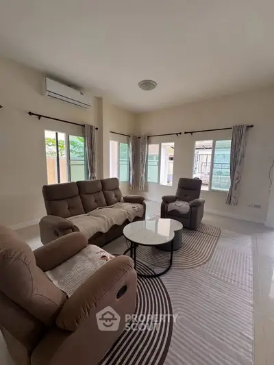 Spacious living room with modern furniture and large windows offering natural light.