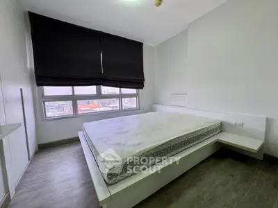 Modern minimalist bedroom with large window and city view, featuring sleek design and neutral tones.