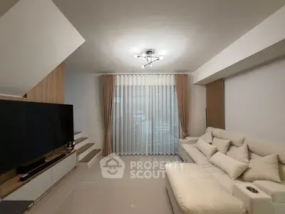 Modern living room with sleek design, large TV, and comfortable seating