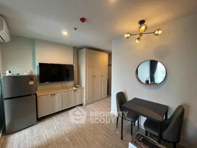 Modern living room with stylish furniture and wall-mounted TV in a cozy apartment.