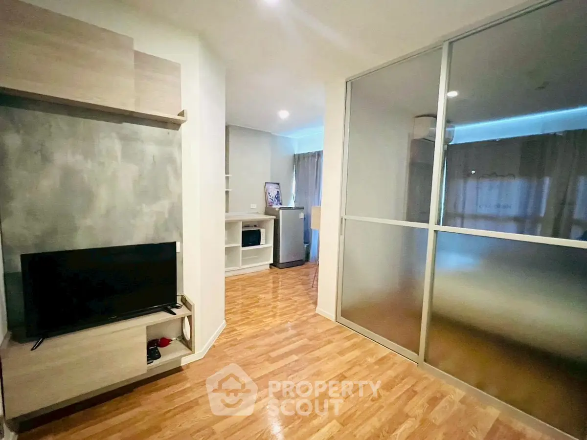 Modern living room with wooden flooring and sliding glass partition