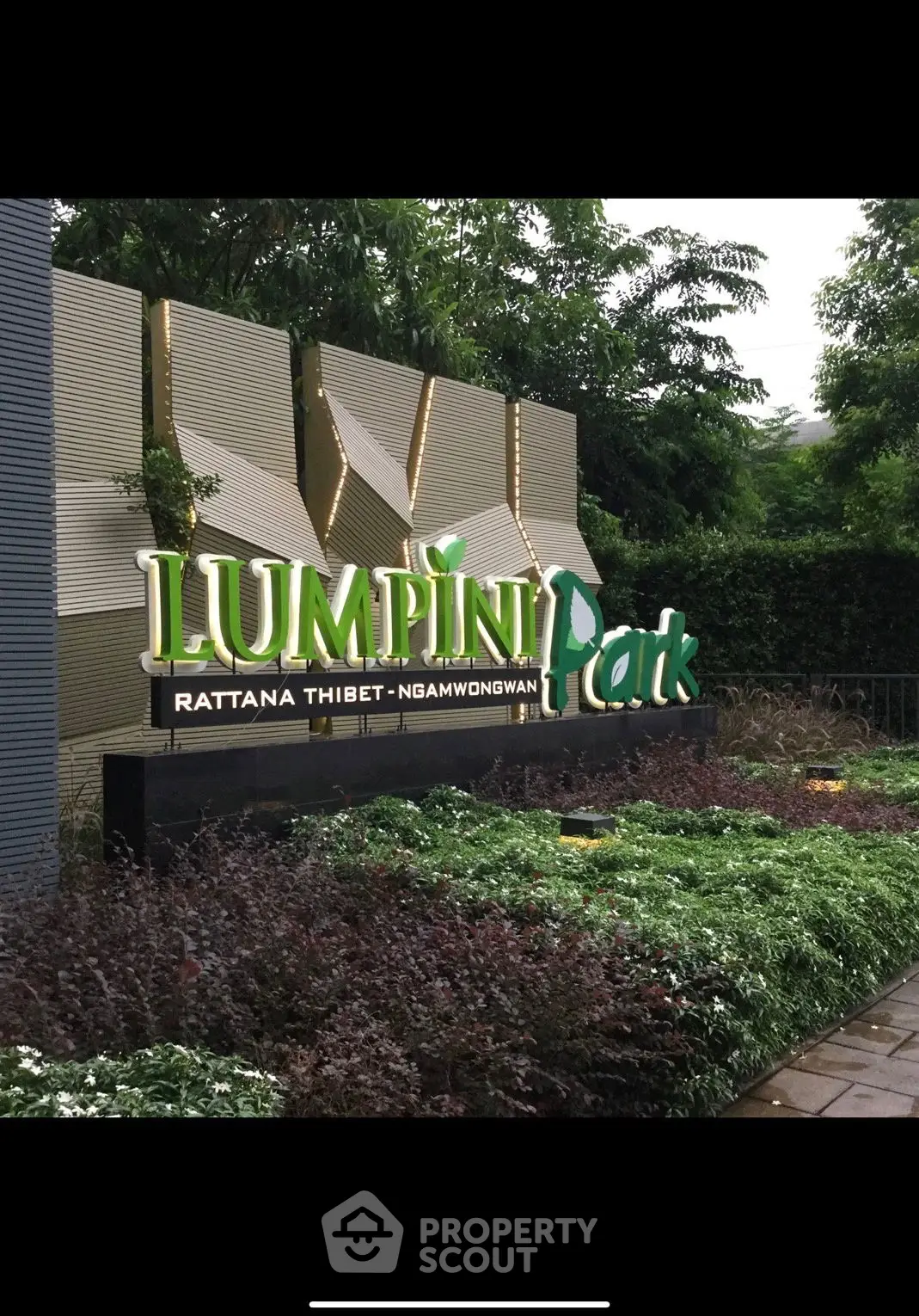 Lush entrance of Lumpini Park Rattana Thibet Ngamwongwan with modern signage and greenery.