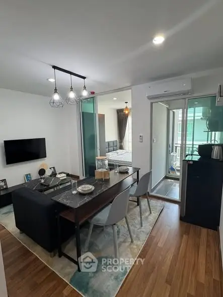 Modern living room with dining area and view into bedroom, featuring sleek furniture and stylish decor.