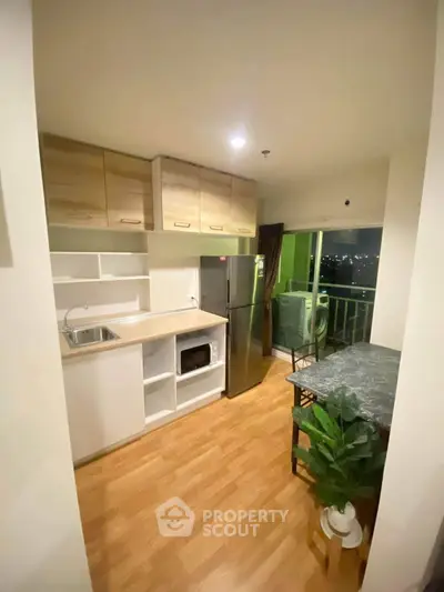Modern kitchen with sleek appliances and cozy dining area overlooking city view.