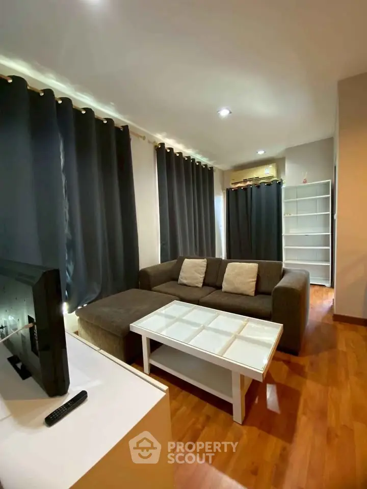 Modern living room with cozy sofa and stylish decor in a well-lit apartment.