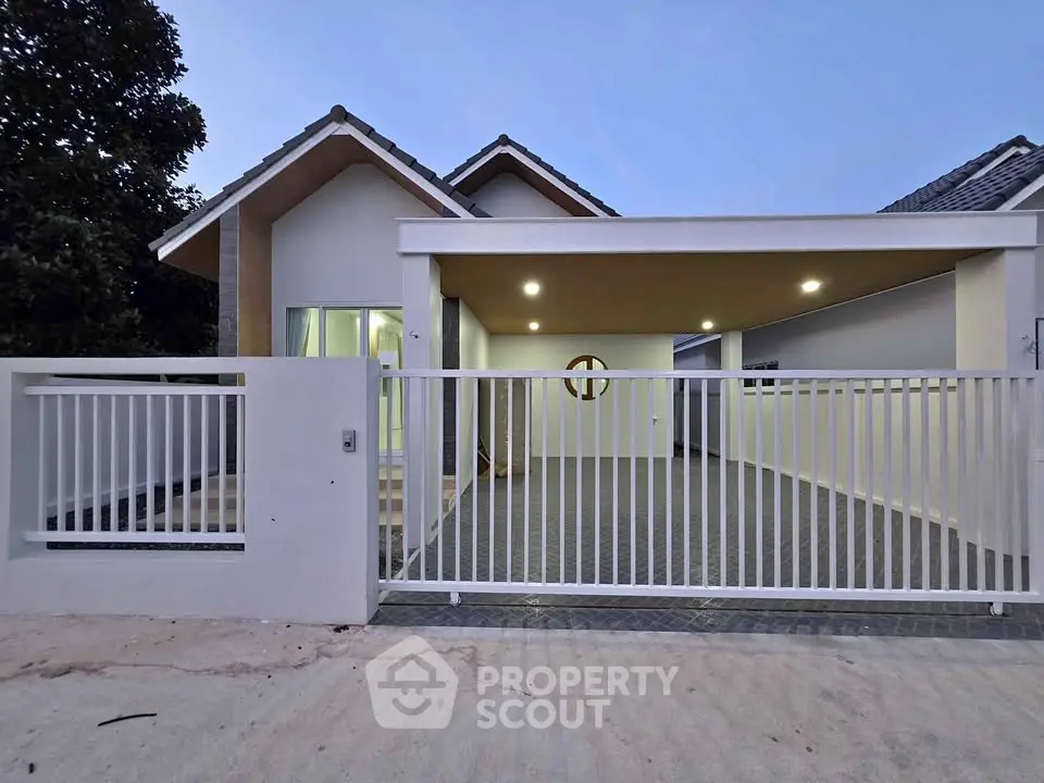 Modern single-story house with gated entrance and driveway