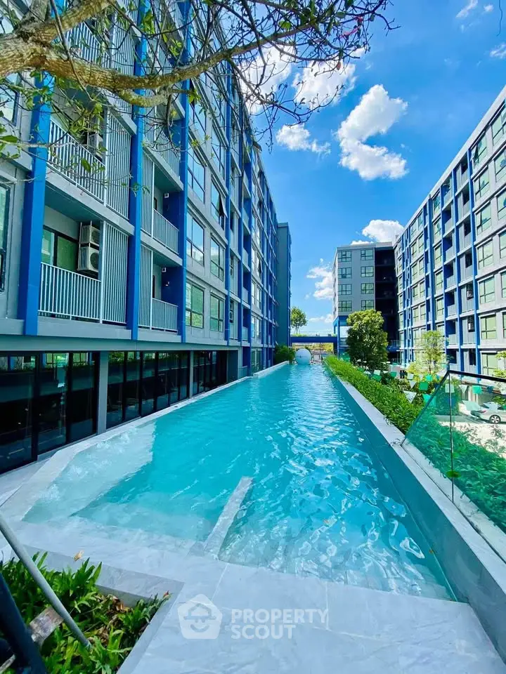 Modern apartment complex with a stunning outdoor pool and lush greenery.