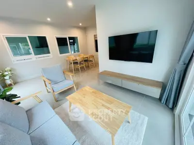 Modern living room with sleek furniture and wall-mounted TV