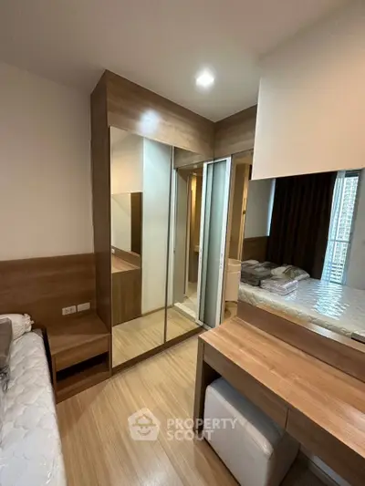 Modern bedroom with wooden flooring and mirrored wardrobe