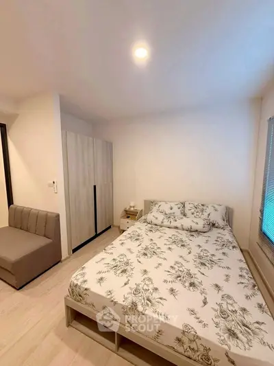 Cozy bedroom with floral bedding and modern wardrobe in a bright apartment.