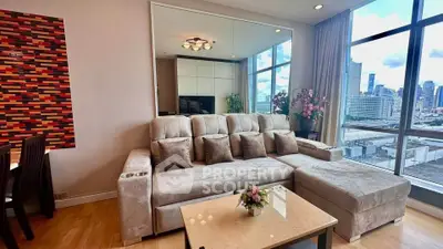 Luxurious living room with plush sofa and stunning city view through large windows.