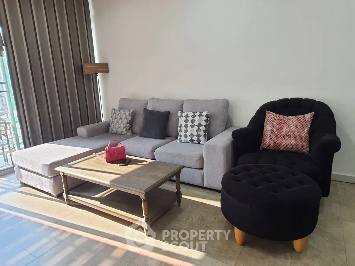 Spacious living room with modern sofa and stylish armchair, perfect for relaxation and entertaining.