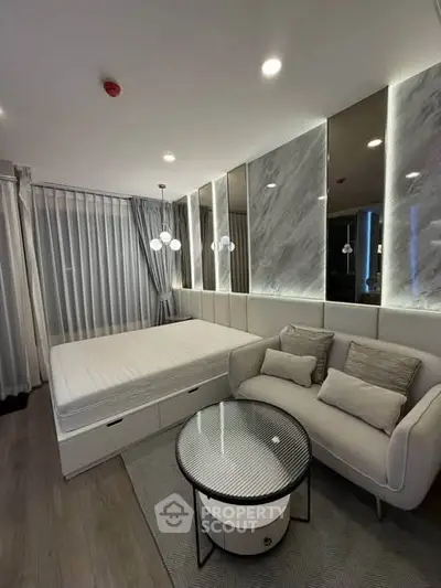 Modern bedroom with stylish decor, featuring a cozy bed, elegant sofa, and chic lighting in a contemporary apartment.