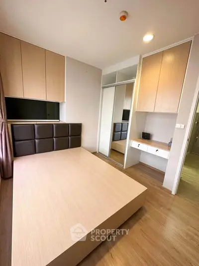 Modern bedroom with wooden flooring and built-in storage solutions