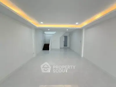 Spacious modern living room with sleek white tiles and recessed lighting