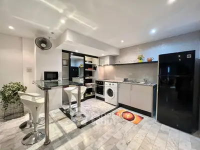 Modern kitchen with sleek appliances and stylish breakfast bar in a contemporary apartment.