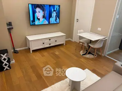 Cozy living room with wooden flooring, wall-mounted TV, and compact dining area.