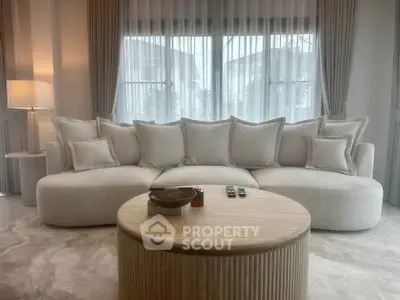 Elegant living room with plush sofa and round wooden coffee table, perfect for modern comfort and style.