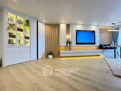 Spacious modern living room with elegant built-in shelving and large flat-screen TV.