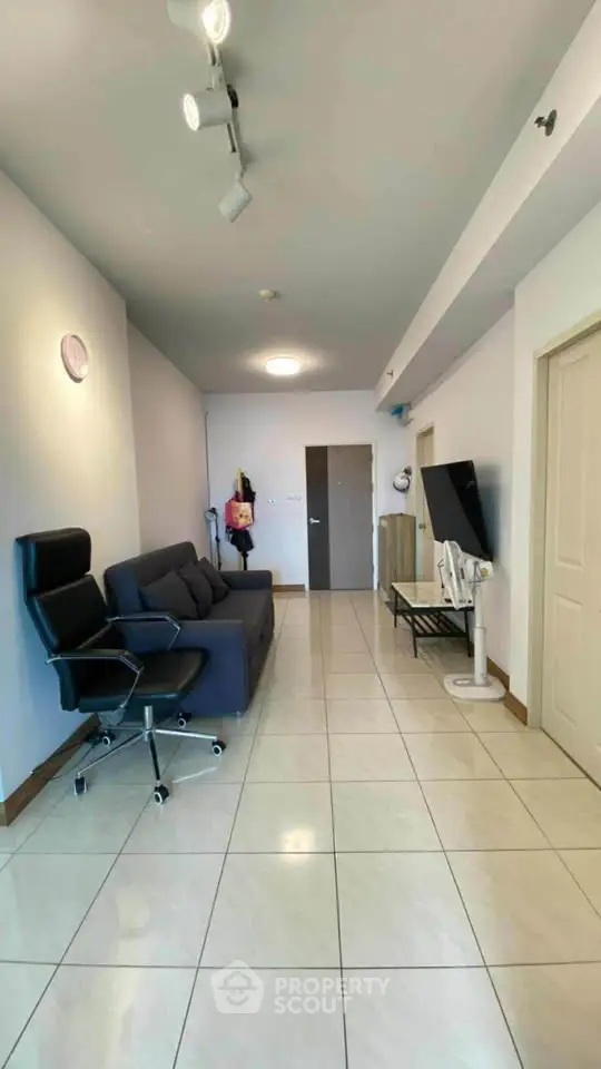 Spacious living room with modern furniture and sleek tile flooring in a contemporary apartment.