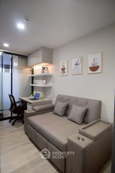 Modern living room with stylish sofa and workspace, perfect for urban living.