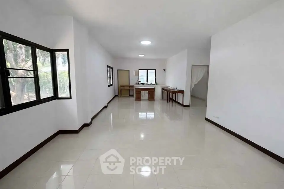 Spacious open-plan living area with large windows and modern kitchen