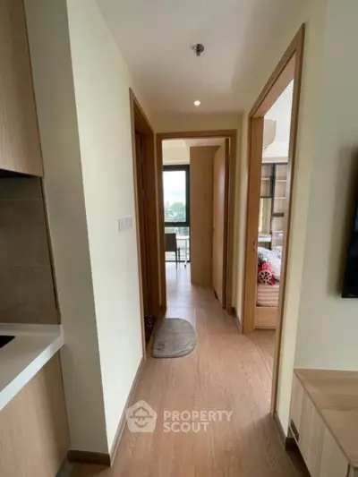 Modern apartment hallway with wooden flooring and natural light
