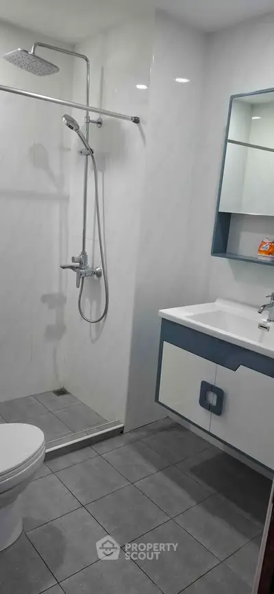 Modern bathroom with sleek shower and stylish vanity in contemporary apartment.