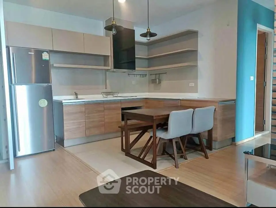 Modern kitchen with sleek cabinetry and dining area in open layout apartment