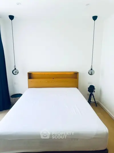 Modern minimalist bedroom with stylish pendant lights and wooden headboard, perfect for serene living.