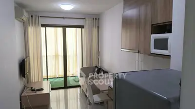 Cozy apartment living room with modern kitchen and balcony view.