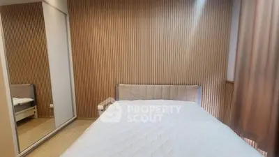 Modern bedroom with wooden panel walls and mirrored wardrobe