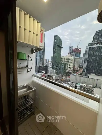 High-rise balcony with cityscape view, featuring a compact utility sink and storage shelves.
