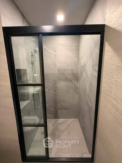 Modern bathroom shower with sleek glass door and elegant tile design.