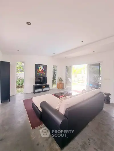 Spacious living room with modern decor and garden view, perfect for relaxation and entertainment.