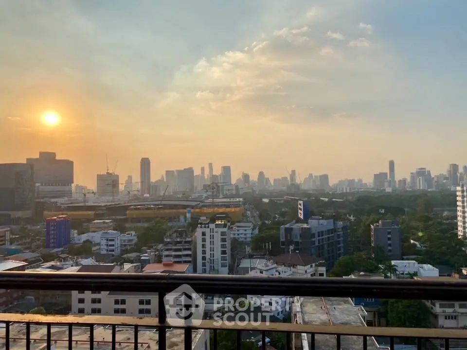 Stunning cityscape view from a high-rise balcony at sunset, showcasing urban skyline and vibrant atmosphere.