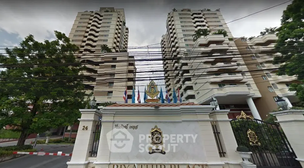 Luxurious high-rise building with elegant entrance and international flags, ideal for upscale urban living.