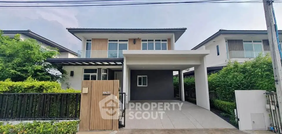 Modern two-story house with spacious driveway and lush greenery